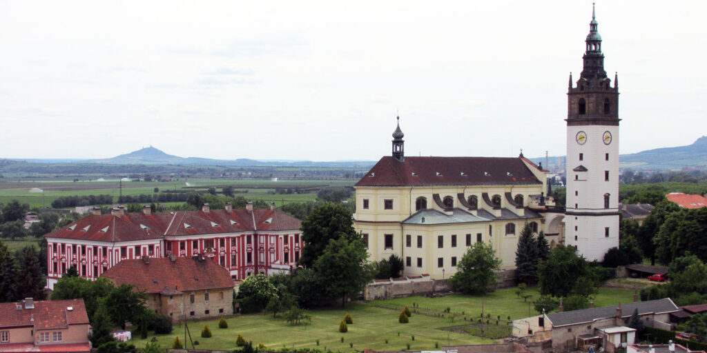 Pohled na katedrálu sv. Štěpána v Litoměřicích s hradem Hazmburk na obzoru.
