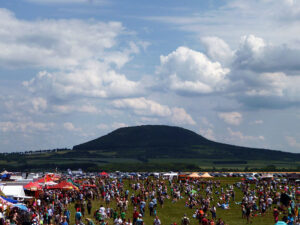 Návštěvníci Memorial Air Show s horou Říp v pozadí