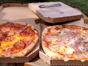 Dvě čerstvě upečené pizzy z Pizzy pod Řípem v Mnetěši.