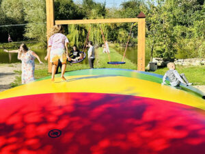Děti skáčou na velké zapuštěné trampolíně v Resortu Svět.