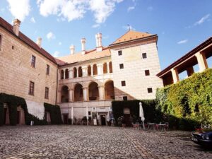 Historické nádvoří Mělnického zámku s renesančními arkádami